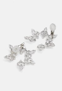 Pendientes de plata con un diseño floral que presenta cinco formas de pétalos, superficies texturizadas y un respaldo circular. Ligeros y modernos.