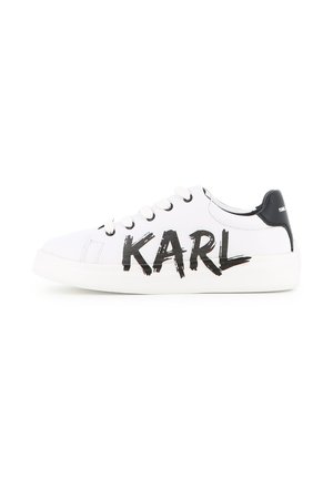 Baskets basses blanches avec languette de talon noire et texte noir "KARL" en police de traits de pinceau gras sur le côté, fermeture à lacets.