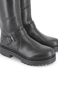 Botas negras de cuero hasta la rodilla con una suela de goma resistente, que cuentan con una correa y hebilla en el tobillo, textura suave y punta redondeada.