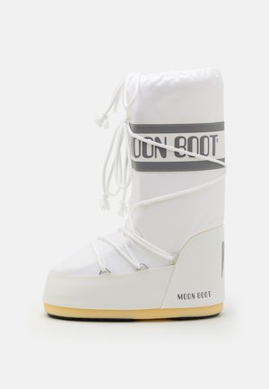 Valge soojustatud saabas, millel on polsterdatud vars, tõmbluku sulgemine ja halli logo riba. Omab ümarat varvast ja kummist tallat.