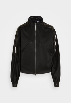Giacca sportiva nera con chiusura a zip, colletto alto, strisce nere lucide sulle maniche, polsini elasticizzati e due tasche frontali con zip.