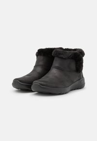 Botas negras hasta el tobillo hechas de cuero suave con un lujoso cuello de piel negra. La puntera redondeada y la suela de goma flexible ofrecen comodidad y facilidad de uso.
