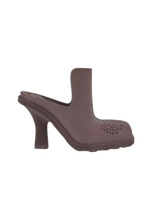Mule marron à talon haut et large, empeigne fermée perforée, et ouvert à l'arrière type slip-on.