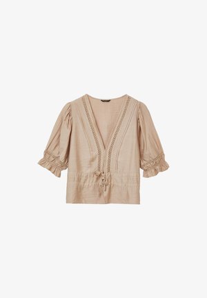 Light beige blouse with a deep V-neck, puff sleeves, and smocked cuffs. Features lace detailing down the front and a drawstring waist.