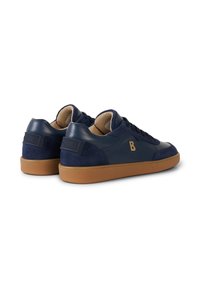 Paire de baskets basses bleu marine avec semelles en caoutchouc couleur tan, panneaux en daim et cuir, et un logo "B" doré sur le côté.