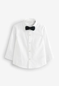 Chemise blanche à manches longues boutonnée avec col classique et nœud papillon noir, présentée sur un fond blanc uni.