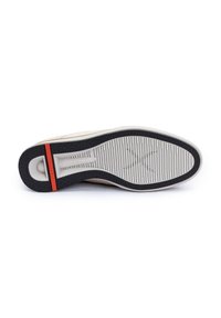 Sneaker-Sohle aus weißem und schwarzem Gummi mit strukturierten Grip-Mustern. Besitzt einen roten Akzent an der Ferse und eine glatte, abgerundete Form.