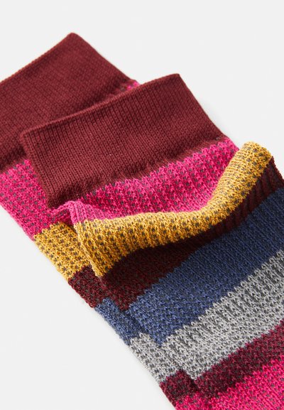 Färgglada strumpor med horisontella ränder i vinröd, rosa, gul, blå och grå. Strukturstickat material med ribbad mudd.