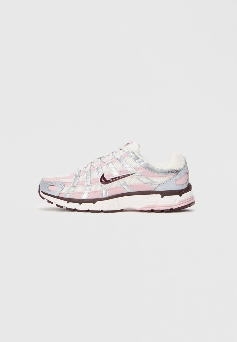 Bijele, ružičaste i srebrne Nike P-6000 tenisice s mrežastim gornjištem, reflektirajućim detaljima i tamnoplavim Swoosh logom na jednostavnoj svijetloj pozadini.