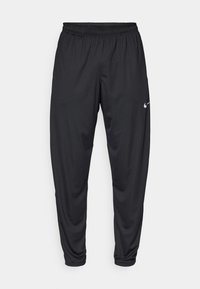 Fekete sportnadrág elasztikus derékpánttal, szűkülő lábakkal és egy kisebb fehér Nike logóval a bal combon. Sima anyag, nincs mintázat.