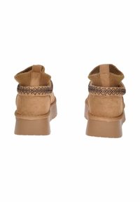 Stivaletti alla caviglia in suede color beige con un colletto in maglia marrone strutturata, tacco robusto e cuciture rinforzate lungo il bordo superiore.