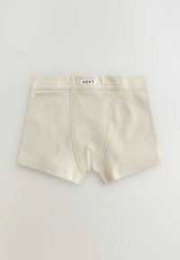 Boxeri din bumbac bej, cu nervuri, cu un panou frontal cusut și eticheta "NEXT" pe banda elastică, așezați plat pe un fond deschis.