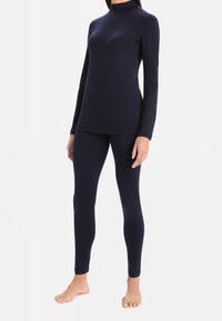 Marinblå, figurnära långärmad topp och leggings, tillverkade av ett smidigt tyg med hög hals, sömlös design och utan synlig hårdvara.