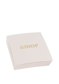 Scatola quadrata di un tenue rosa pallido con una superficie liscia; presenta la parola "amor" in lettere dorate sulla parte superiore. Design sottile e minimalista.