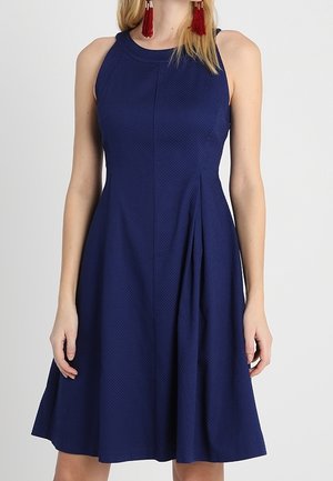 Marineblaues ärmelloses Kleid aus strukturiertem Stoff mit tailliertem Oberteil und ausgestelltem Rock. Es verfügt über einen runden Ausschnitt und dezente Falten, keine sichtbaren Verschlüsse.
