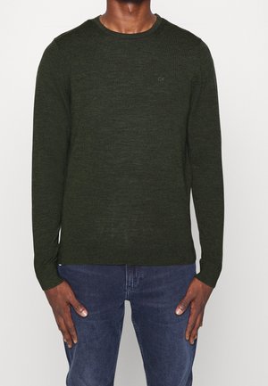 Pull en maille vert foncé avec des manches longues et un col rond, affichant une texture subtile et un petit logo brodé sur la poitrine.