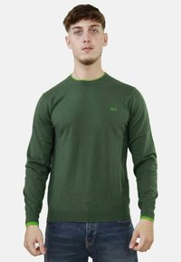 Maglione lavorato a maglia verde con maniche lunghe, dettagli verdi sul colletto e sui polsini, vestibilità slim e un piccolo logo sul petto.