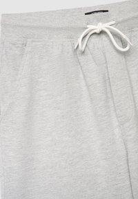 Jasnoszare bawełniane spodnie dresowe z elastycznym paskiem w talii, wyposażone w sznurek do regulacji, boczne kieszenie oraz miękką, teksturowaną powierzchnię.