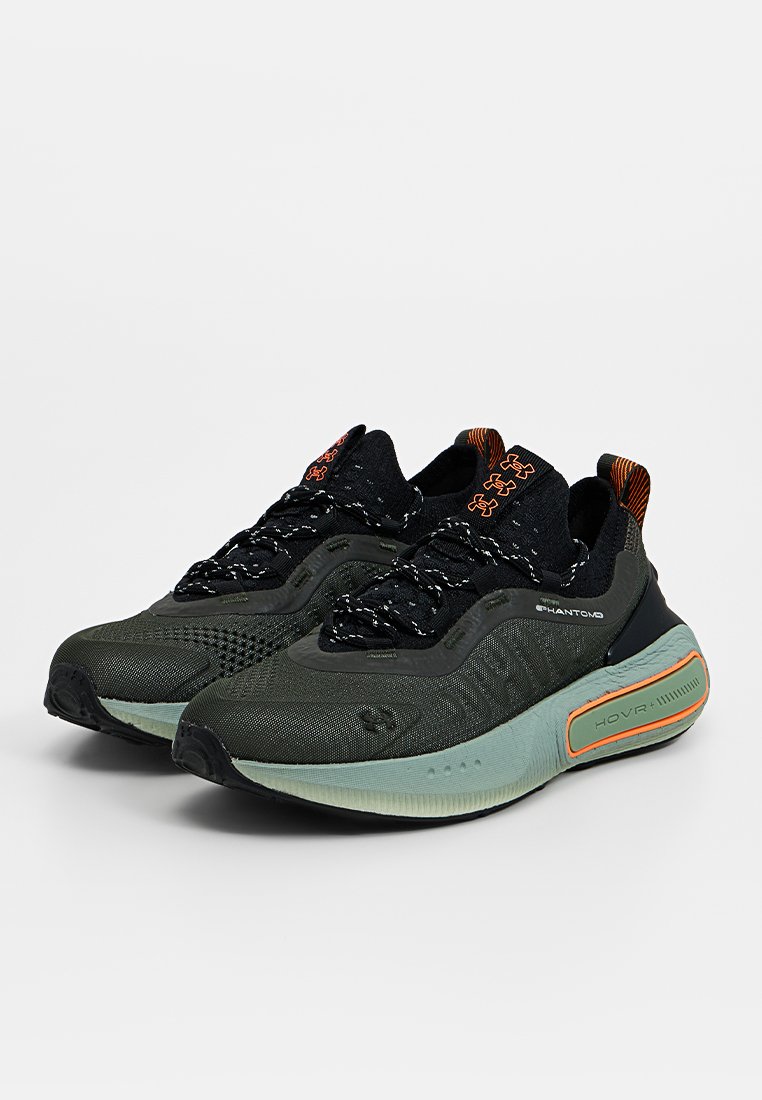 Baskets de sport vertes et noires avec un dessus en mesh texturé, un système de laçage intégré et une semelle rembourrée avec des accents orange et un logo.