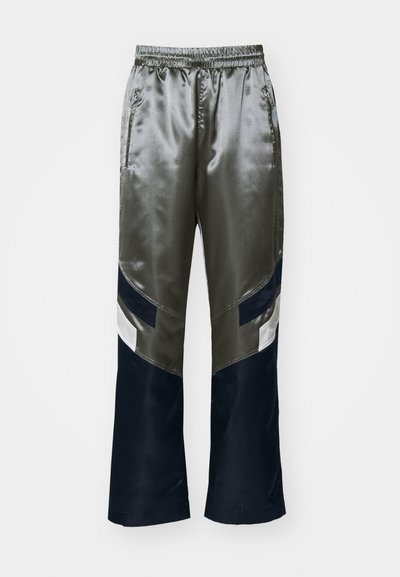Pantalons de survêtement en satin olive et bleu marine avec une coupe décontractée, taille élastique et design color-block avec des accents blancs et bleu foncé.