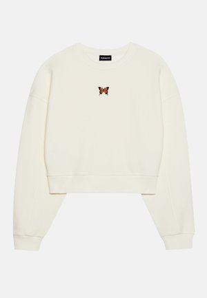 Cream-colored cropped sweatshirt with an embroidered orange butterfly at the center. Features wide sleeves and ribbed cuffs.