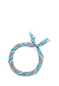 Écharpe en soie bleue à motifs en forme circulaire, avec des rayures alternées aux accents jaunes et blancs, nouée en haut.