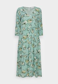 Vestido midi verde menta con mangas 3/4 y un estampado floral que presenta flores blancas y amarillas con contornos verde oscuro.