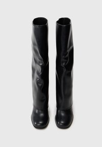 Black knee-high boots made of smooth, shiny leather with a structured design, featuring a square toe and a slightly crinkled texture.