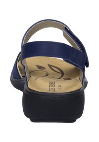 Laivastonsininen nahkasandaali, jossa on kaksi säädettävää remmiä, pehmustettu beige pohja ja musta kumipohja. Ominaisuuksiin kuuluu minimalistinen muotoilu ja tasainen malli.