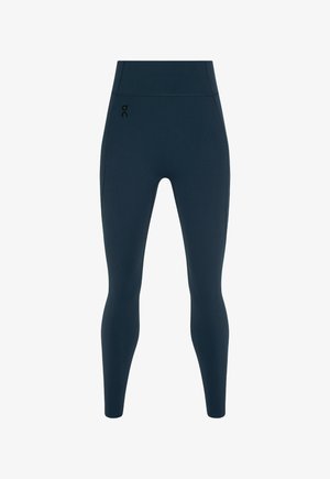 Tumši zili legingi no elastīga, gluda materiāla; augsts viduklis; mazs melns logotips kreisajā pusē; piegulošs dizains, kas sašaurinās pie potītēm.