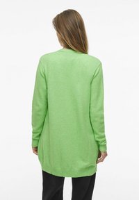 Långärmad cardigan i ljusgrön, med ribbad fåll och muddar, tillverkad av mjukt material med en avslappnad passform, visad bakifrån.