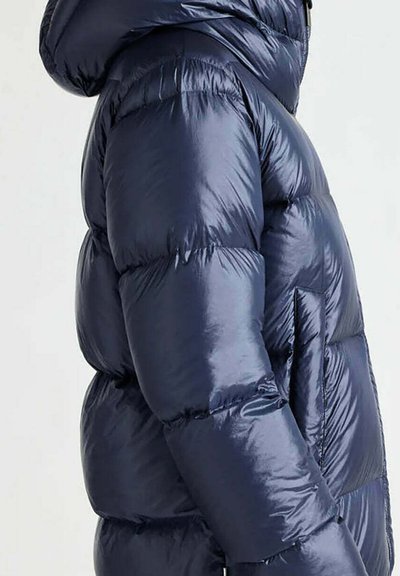 Giacca a piumino blu navy, lucida, con cappuccio e tasca laterale, con sezioni trapuntate per l'isolamento e una texture liscia.
