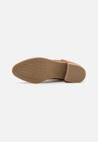 Suela de zapato en tono marrón con un patrón texturizado. Cuenta con una base acolchada y un ligero tacón. Material duradero diseñado para ofrecer comodidad y tracción.