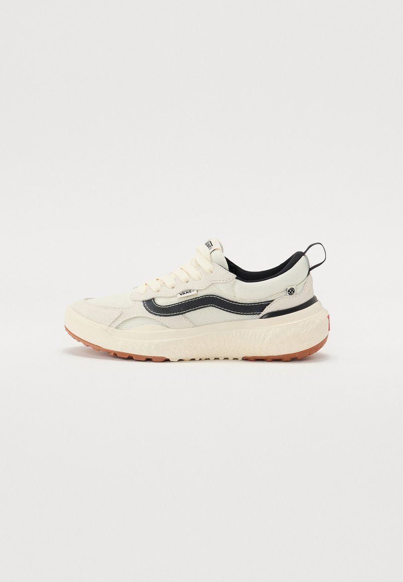 Cream-colored sneaker with a black wave design, featuring a textured sole, chunky shape, and contrasting rubber outsole.