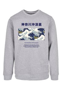 Szürke pulóver hosszú ujjakkal, amelyen a "Kanagawa nagy hulláma" nyomat található, valamint japán és angol szöveg.