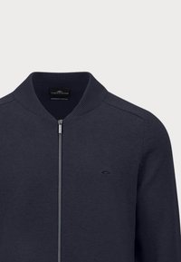 Marineblauwe cardigan van zacht katoen, met een ritsluiting, geribbelde kraag en een subtiele logo aan de linkerkant.