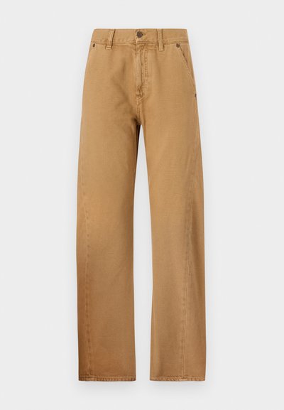 Victoria Beckham TWISTED LOW RISE SLOUCH - Calças de ganga de corte relaxado - beige