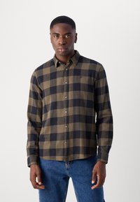 Cămașă flanelată în carouri verzi și bleumarin cu guler butonat, mâneci lungi și pocket frontal; realizată dintr-o țesătură moale și texturată.