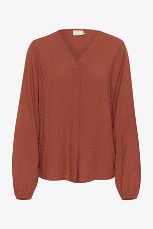 Rūsganbrūna blūze ar garām piedurknēm, V veida kakla izgriezums, teksturēta auduma ar izceltiem punktiem. Savilkti aproces un centrāla šuvuma detaļa.