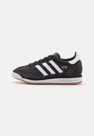 Czarno-białe sneakersy Adidas SL '72 z zamszowymi nakładkami, trzema białymi paskami po bokach, białą zakładką na pięcie i gumową podeszwą.
