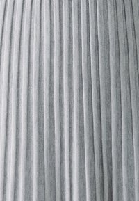 Harmaa pleated-kangas, jossa on tasaisesti sijoitettuja pystysuoria raidoja. Kankaan pinta näyttää pehmeältä ja kevyeltä, sopii käyttöön vaatteissa tai verhoissa.