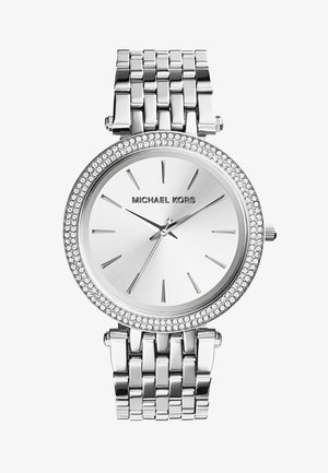 Montre-bracelet Michael Kors argentée avec bracelet à maillons métalliques, cadran minimaliste, index fins et lunette sertie de cristaux autour du cadran.