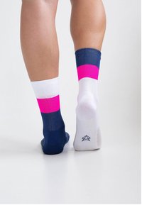 Bunte Socken mit einem Design aus marineblauen, weißen und leuchtend pinken Bereichen, die eine Mischung aus glattem und strukturiertem Stoff zeigen.