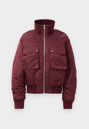 Veste bomber bordeaux avec un col haut en côtes, fermeture éclair à l'avant, deux grandes poches à rabat avec boutons-pression, et des poignets et un ourlet en côtes.