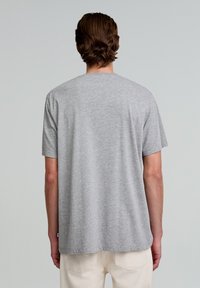 Grijze katoenen t-shirt met korte mouwen, ronde hals en een iets losse pasvorm, met een rechte zoom aan de achterkant.