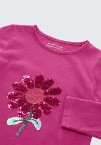 Fuchsia langekatoenen T-shirt met lange mouwen, voorzien van een groot, met sequins versierd bloemenmotief in verschillende tinten roze, met een ronde halslijn en zachte katoenen textuur.