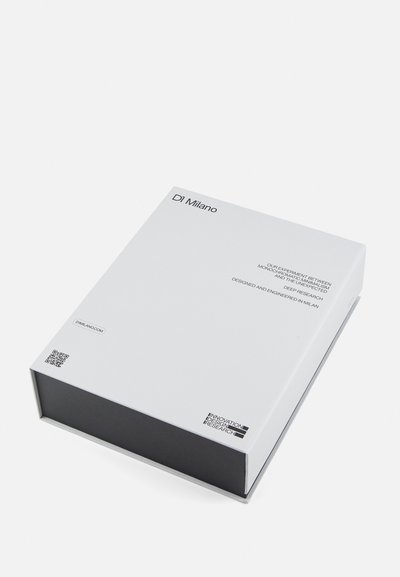 Λευκό ορθογώνιο κουτί με μαύρη βάση, με μινιμαλιστικό κείμενο και λογότυπα στο καπάκι. Περιλαμβάνει κωδικό QR και λεπτομέρειες branding.