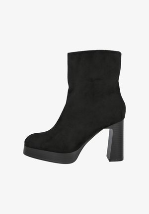 Botín negro de ante hasta el tobillo con un tacón alto grueso y punta redondeada, visto de lado sobre un fondo blanco.