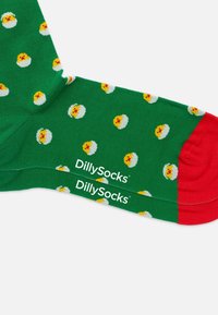 Calze verdi con un motivo di pulcini gialli e conchiglie bianche, con punta rossa e il marchio "DillySocks" stampato in bianco.
