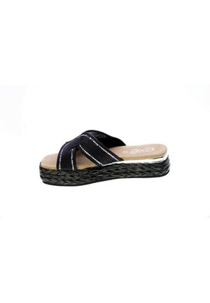 Sandali con zeppa nera, caratterizzati da cinture incrociate in tessuto, una texture intrecciata e un intersuola in stile sughero. Presentano una morbida soletta color beige.